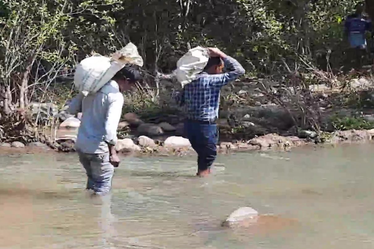 Teachers carry Mid-Day Meal ration in remote village of Balrampur in Chhattisgarh