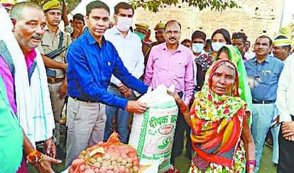 बाढ़ पीड़ितों को राहत किट प्रदान करते डीएम।