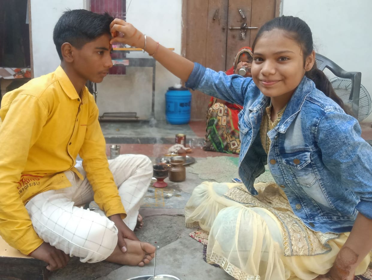 Wishing long life to brothers by applying tilak