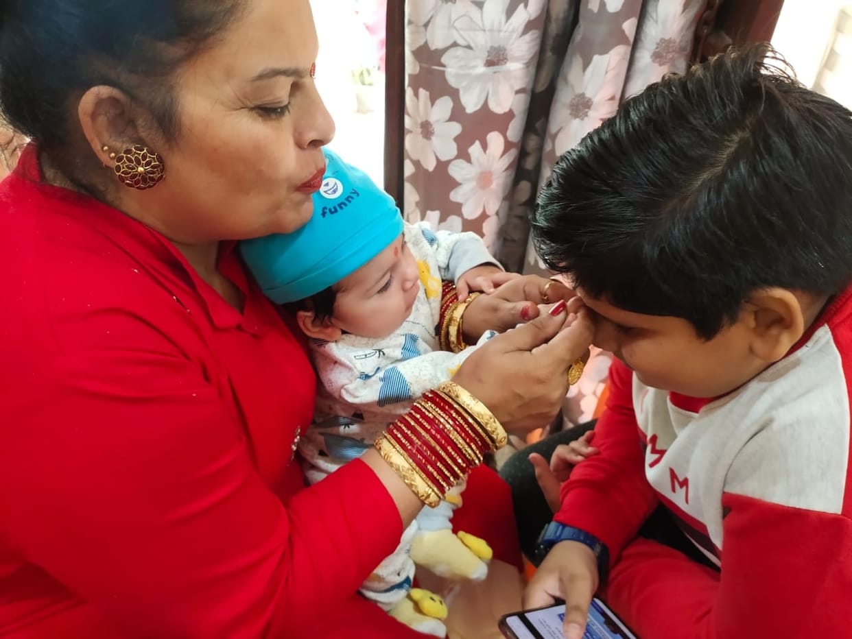 Sisters wish for the long life of their brothers by doing tilak