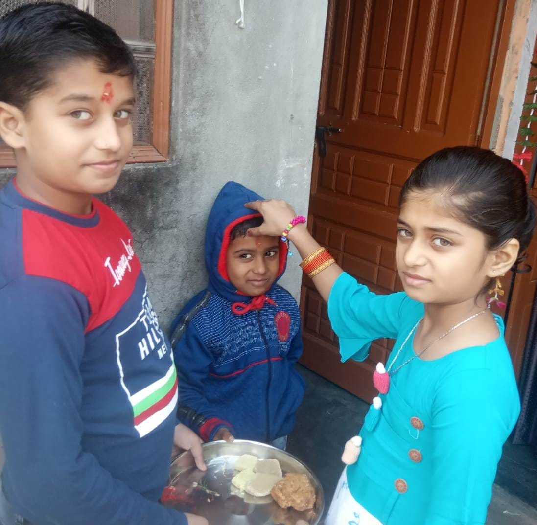 Sisters wish their brothers long life by doing tilak