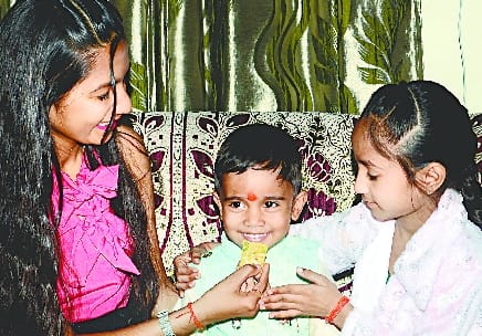 By putting tilak on the forehead of brothers, sisters did