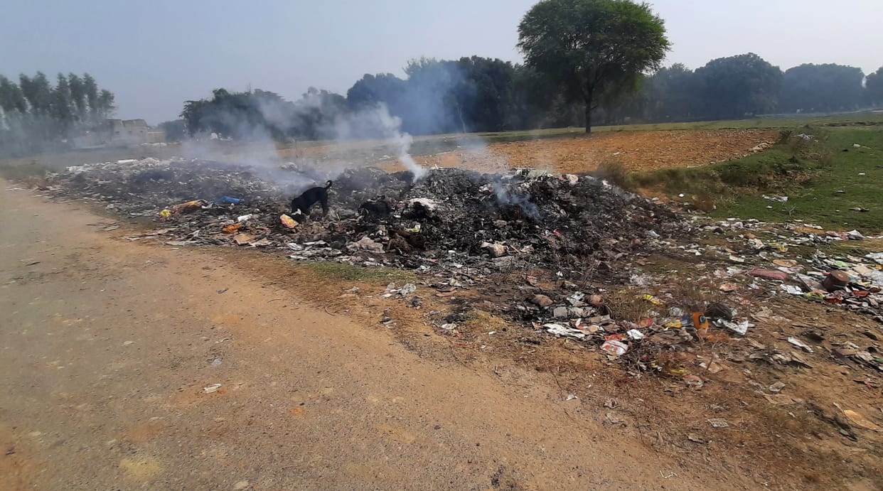 One is throwing garbage on the banks of the river, the disposal is set on fire from above