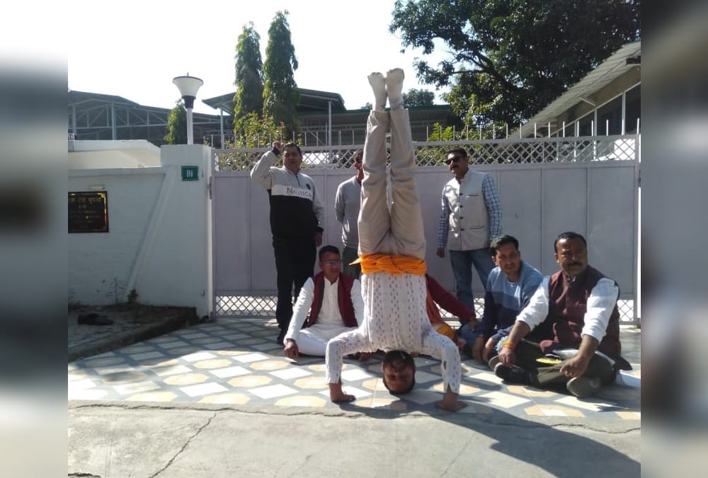 Chardham Devasthanam Board: priest doing protest and Shirshasana in front of Ministers Residences photos