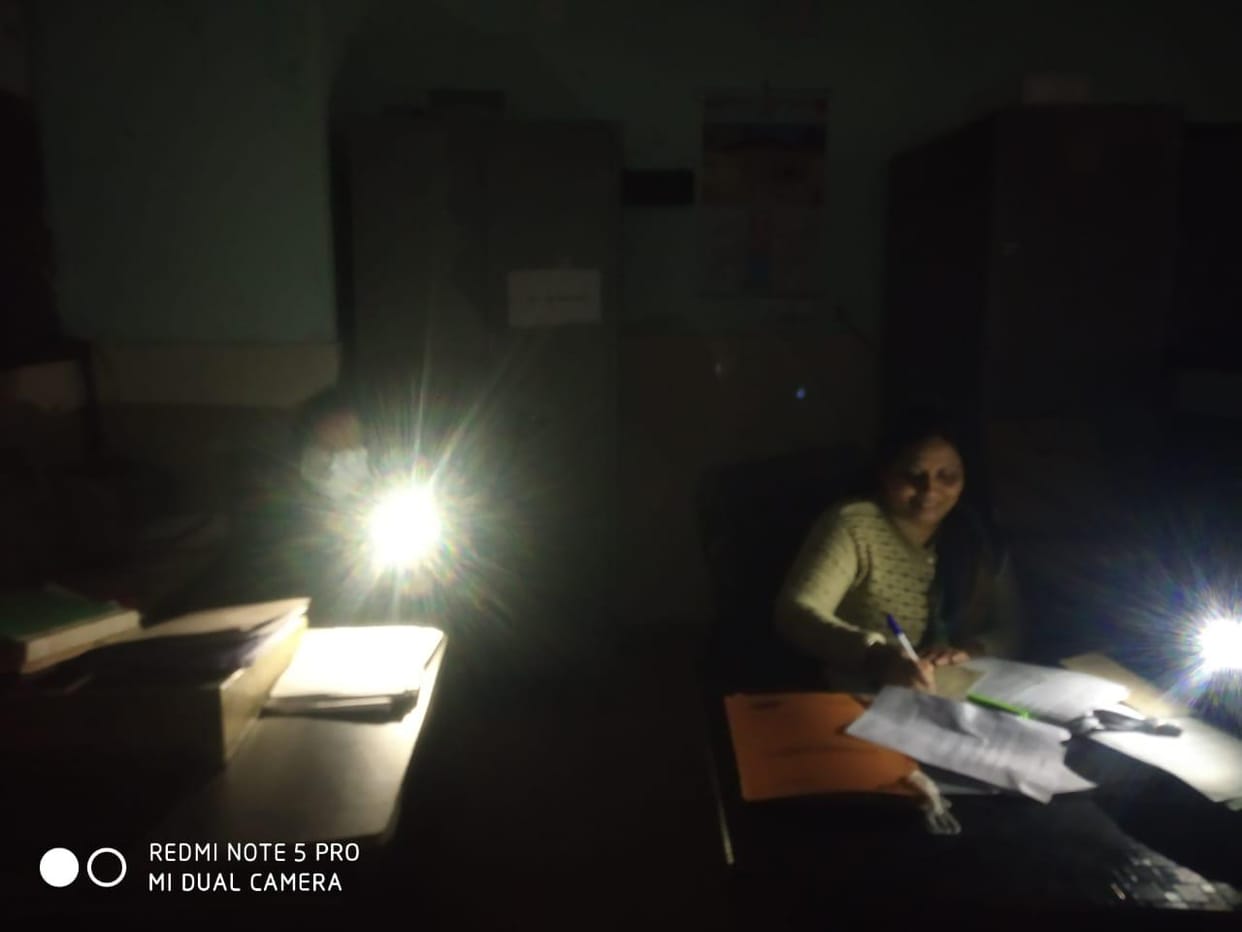 Employees working in mobile torch light due to power cut in Nalagarh