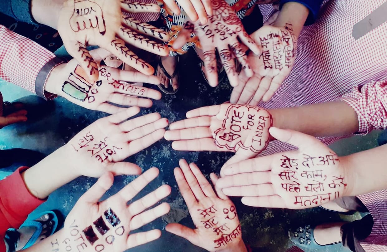Children apply mehndi on their hands and inspire them to vote