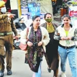 जम्मू में कोरोना टेस्ट करवाने को ले जाता पुलिस कर्मी।
