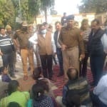 धरने पर बैठे परिजनों को समझाते पुलिस अधिकारी