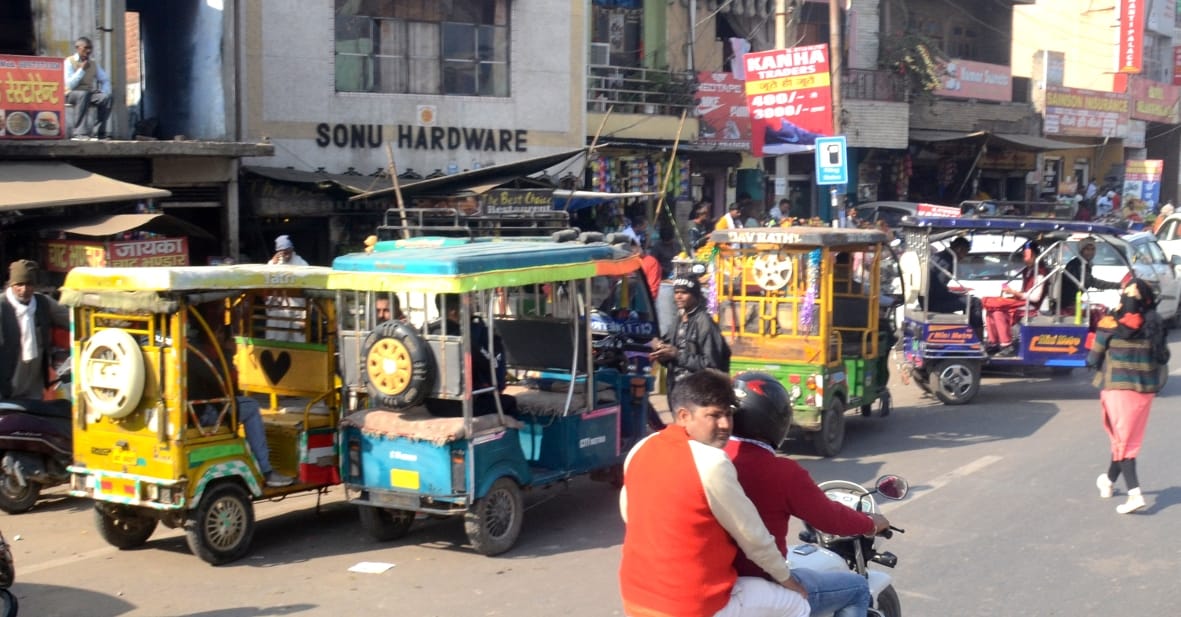 E-rickshaw and three wheeler jammed, traffic police personnel are sitting in shops
