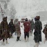 एलओसी पर बर्फबारी के बीच गर्भवती को अस्पताल ले जाते सेना के जवान।