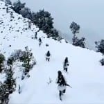 एलओसी पर बर्फबारी के बीच गश्त करते जवान।