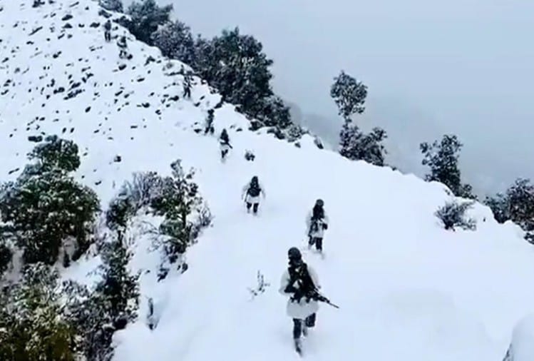 एलओसी पर बर्फबारी के बीच गश्त करते जवान।