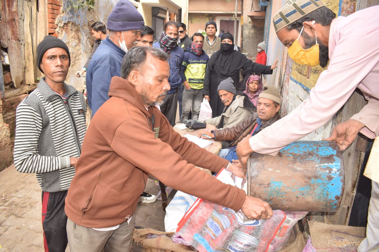 Distributed gram and edible oil by tearing packets containing photos of Modi-Yogi