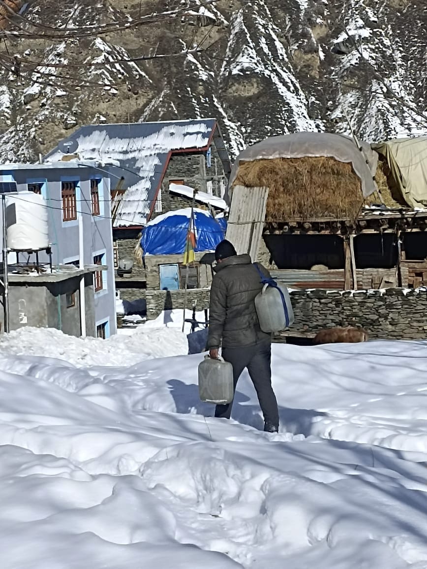 Pipe jam in snowfall, women of Mane village carrying water on mules