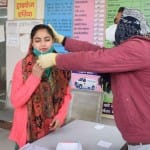कोरोना की जांच करता कर्मचारी