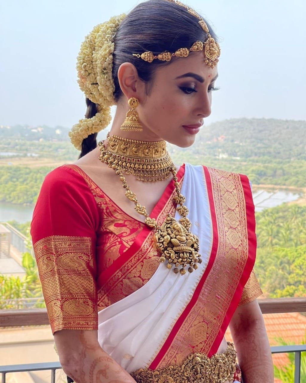 mouni roy bridal look in white silk saree red border with temple jewellery featuring lord ganesha