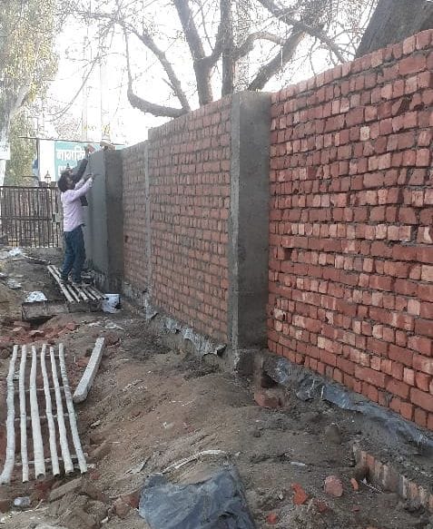 Low level bricks being installed in the boundary wall of the hospital in Panchayat Minister's city