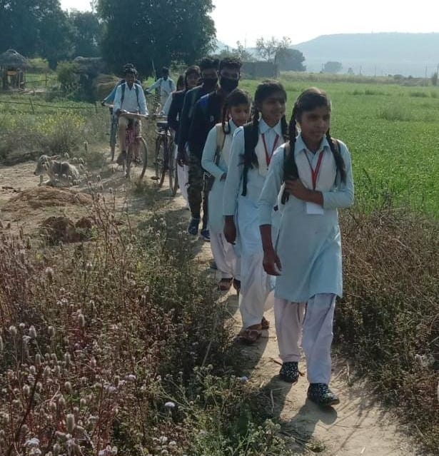 Due to lack of way, students are forced to go to school through the ridge of the fields.