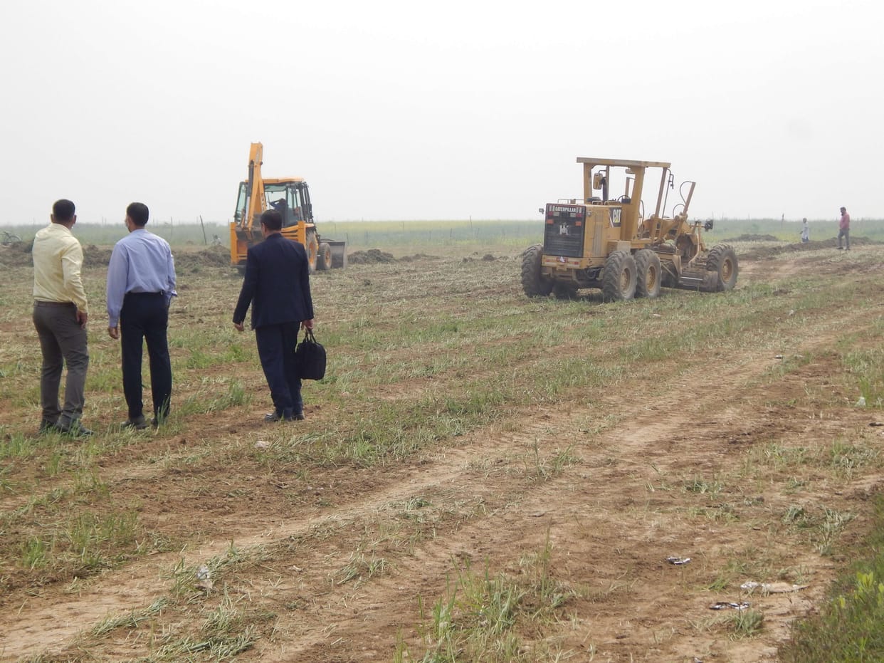 Workers engaged in cleaning the field for the meeting of the Prime Minister