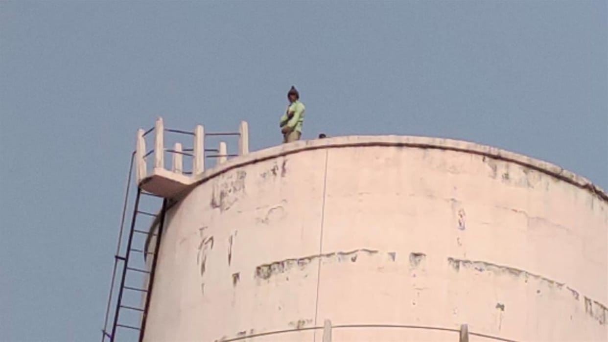 The young man climbed on the tank in a drunken state