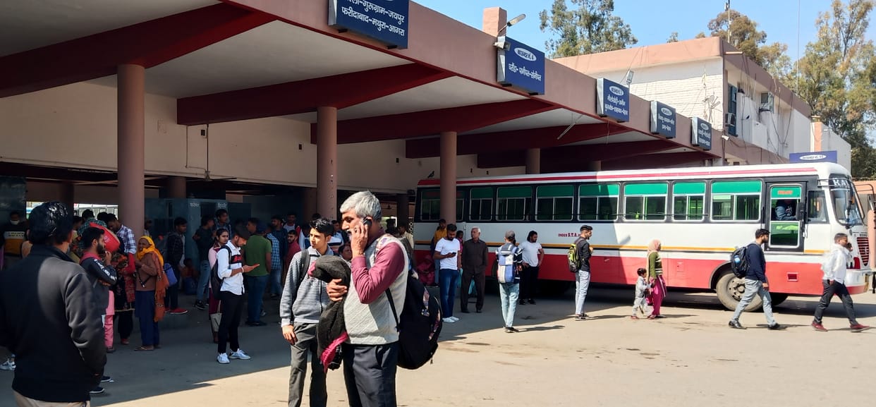 Drivers resting on parked ambulances, troubled by passenger buses