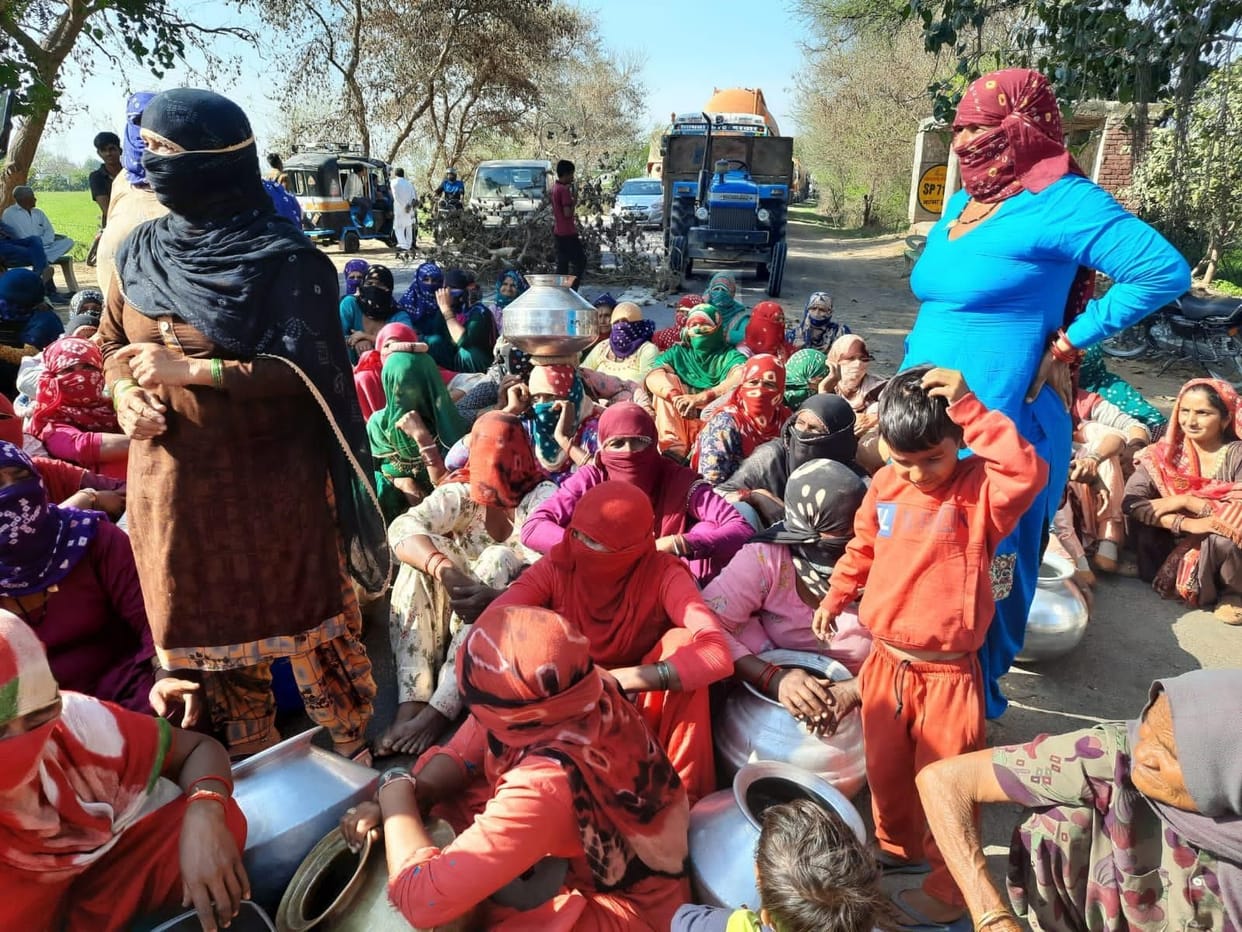 Drinking water crisis: Women sitting on the road carrying tokens
