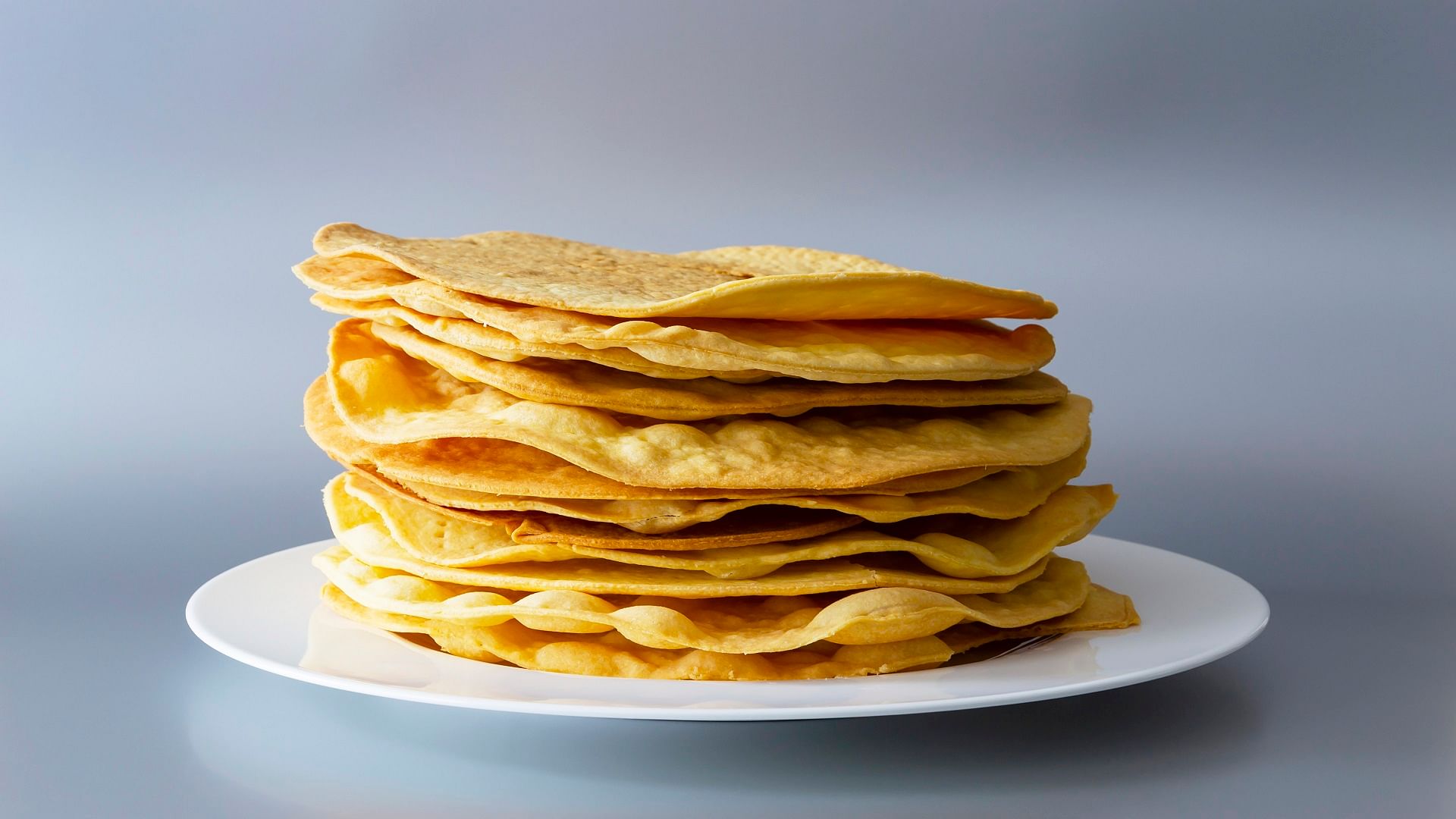 Premium Photo | Indian snacks, pile of deep fried or roasted mung urad dal  crackers or papad which is a side dish in lunch and dinner. served in a  cane basket or