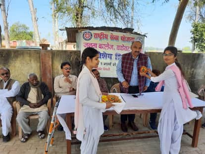 राष्ट्रीय सेवा योजना के शिविर में प्राचार्य डा राजेश को बैज लगाती छात्रा। संवाद