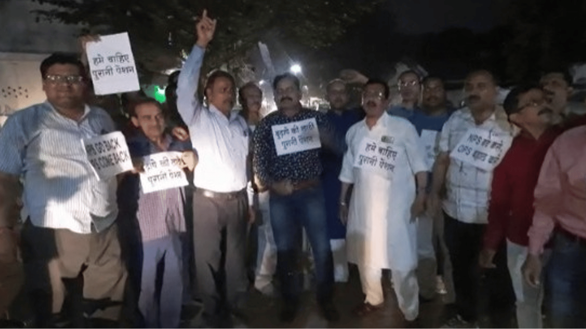 हाथ में तख्तियां लेकर पेंशन बहाली की मांग करते कर्मचारी।