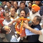 गैस सिलिंडर पर हार चढ़ाते कांग्रेस प्रभारी राजीव शुक्ला।