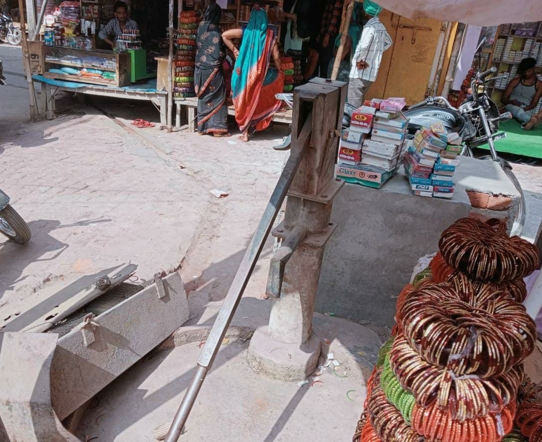 Damaged hand pump, people wandering for water