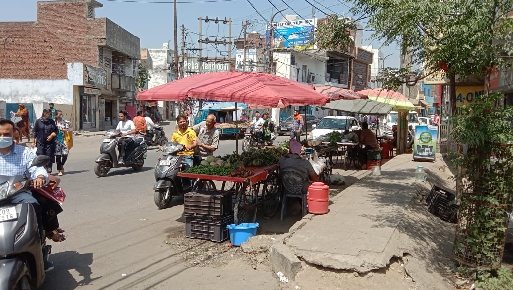 Goods on the sidewalk, pedestrians on the road