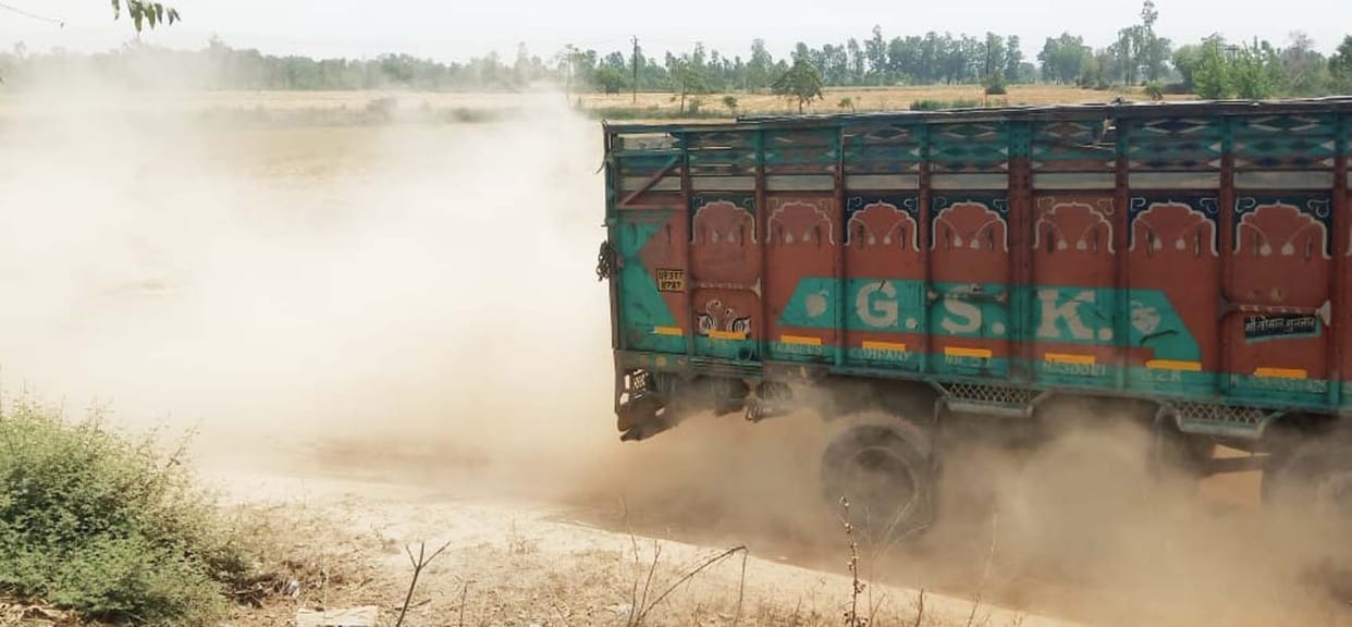 The rough road has not been repaired, the next vehicle is not visible from the dust