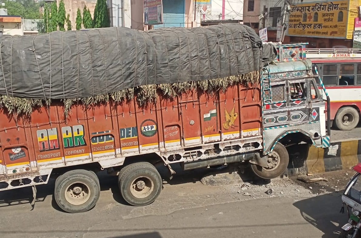 Truck damaged by climbing divider, road blocked