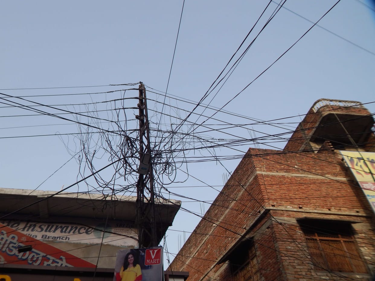 There is a network of wires on the pole from the city to the villages