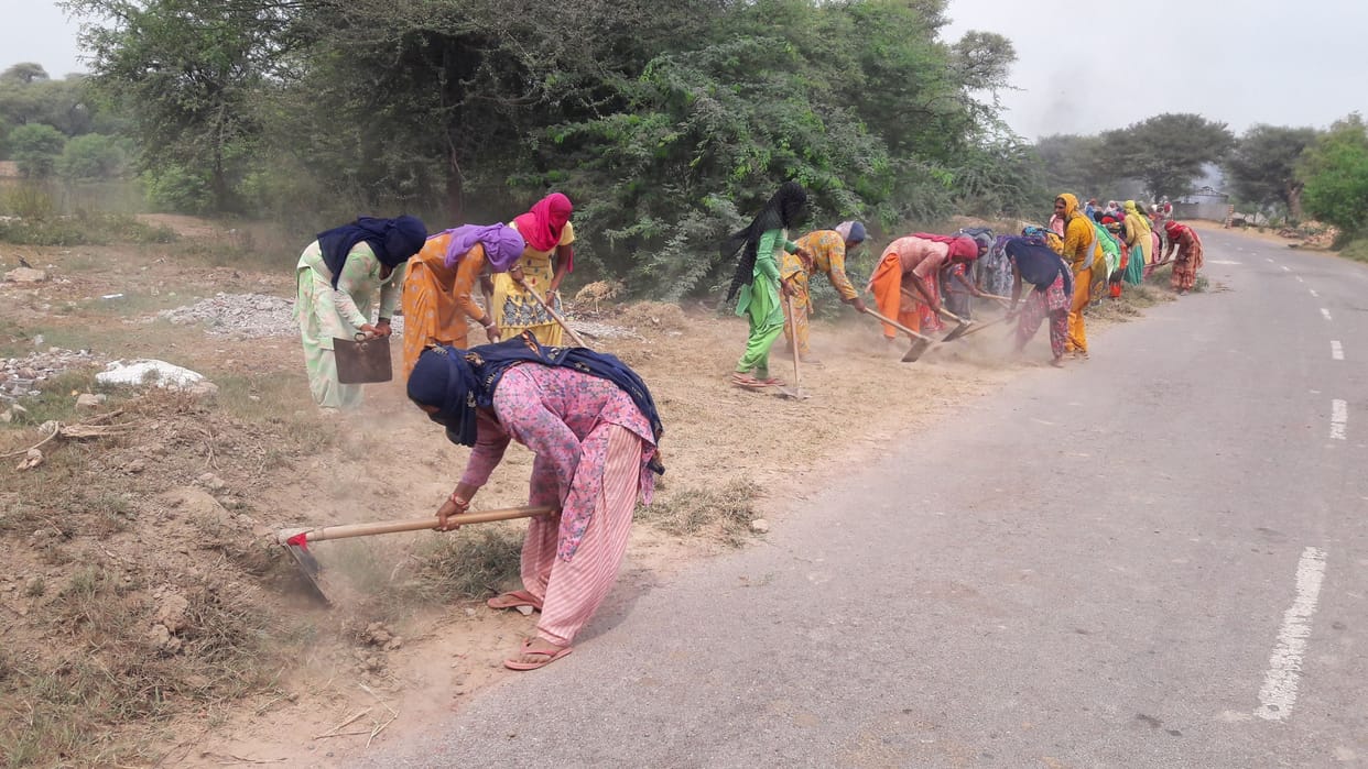 Women sweating in MNREGA shoulder to shoulder with men