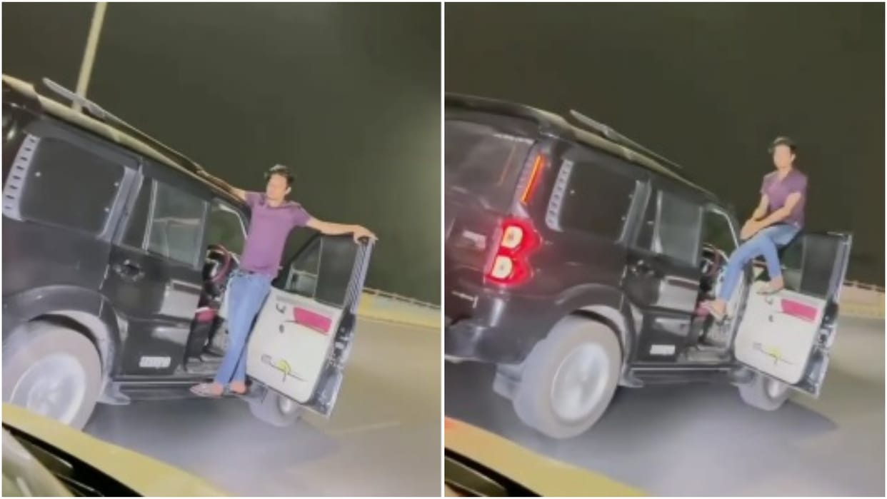 Dangerous stunt of a young man in a moving vehicle leaving steering and sitting at gate of car