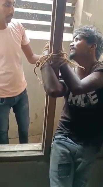 Young man tied in the window was beaten with a stick