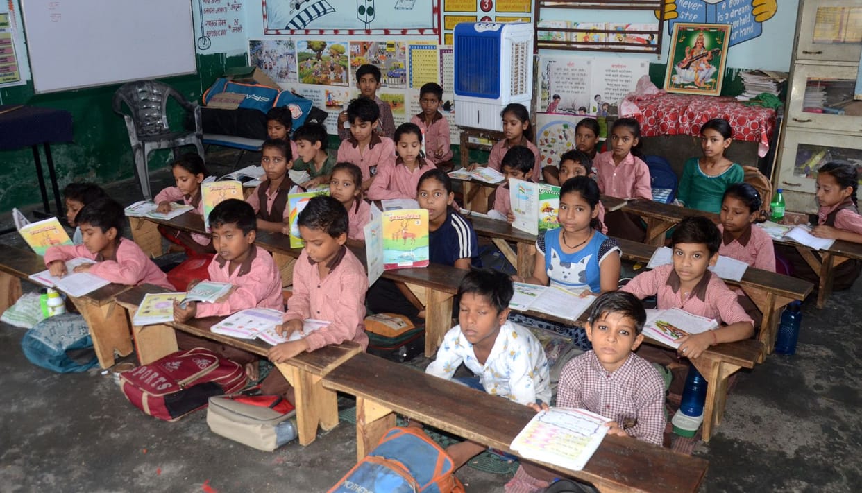 Children reading from old books in new academic session