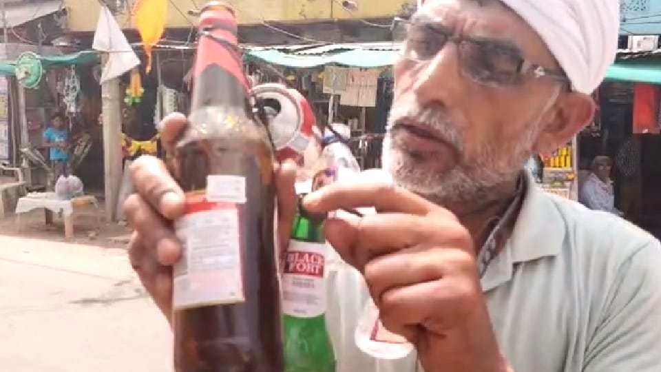Attention Liquor Consumers: Liquor being sold for more than MRP, protested by hanging empty bottles around the neck