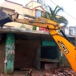 अवैध निर्माण को गिराता बुलडोजर