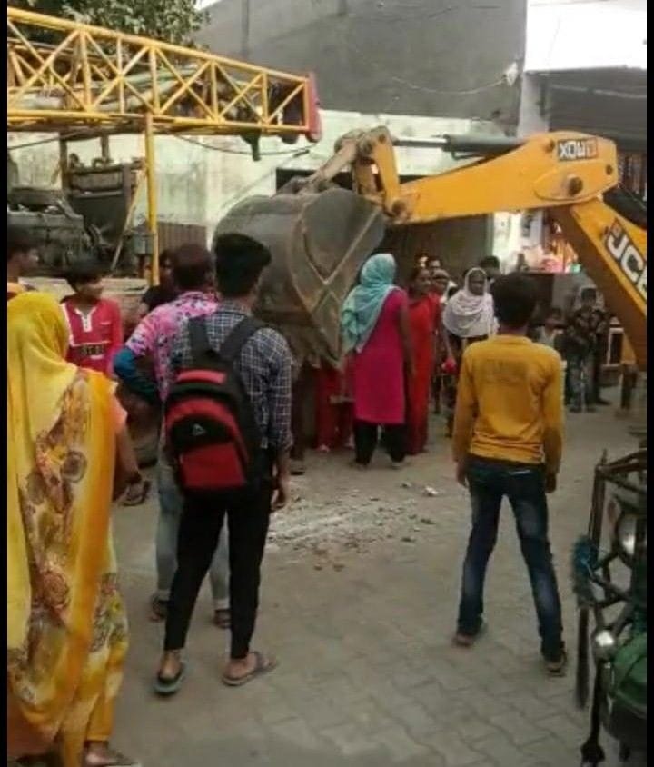 People lying in front of JCB, protest against tube well boring
