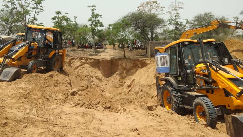 Two farmers working in a well buried in mud at hisar 