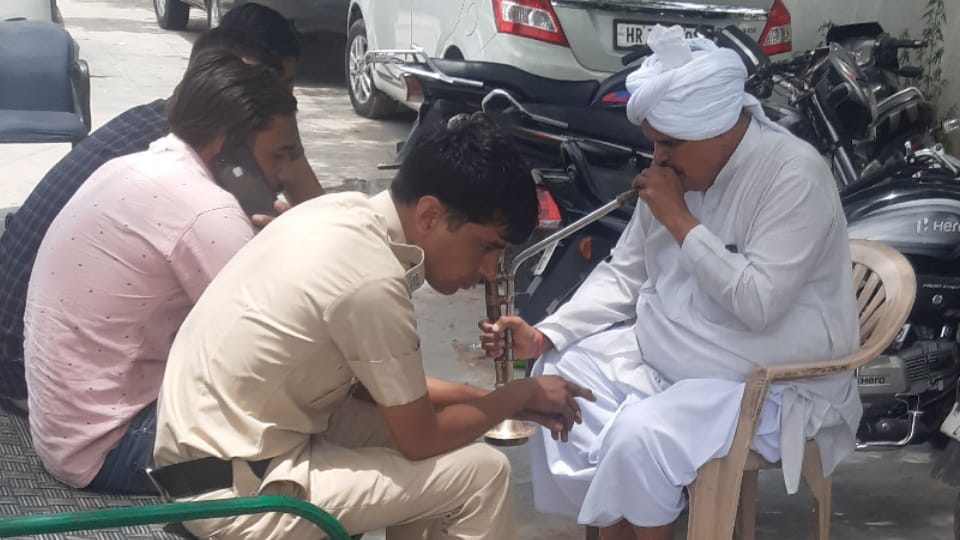 'Nirmal Tau', who stopped smoking beedi-cigarettes at the bus stand, is himself blowing the smoke of hookah