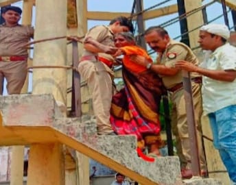Troubled by the beating of sons, the old lady climbed on the overhead tank