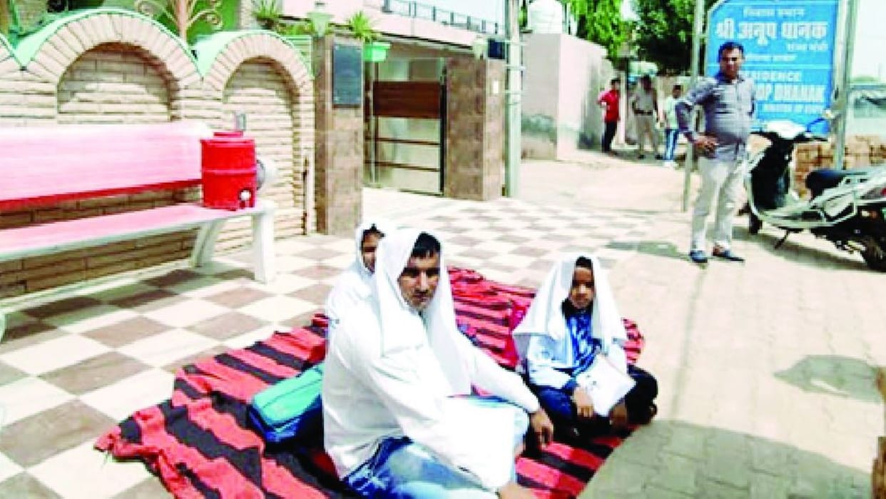 Father sitting on a dharna outside the residence of minister in Uklana for the scholarship of children