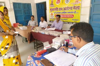 चरवा पीएचसी में आयोजित आरोग्य मेलें मरीजों का इलाज करते स्वास्थ्य कर्मी