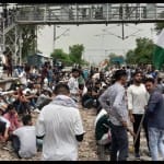 जींद में रेल ट्रैक पर बैठे युवा।