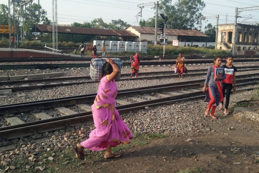 People take risk and cross warehouse railway crossing