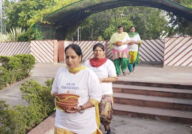 Women are arranging food and water for birds, Kurukshetra